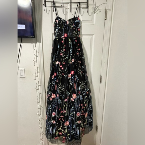 It is black, with flowers and rhinestones. - Picture 1 of 3